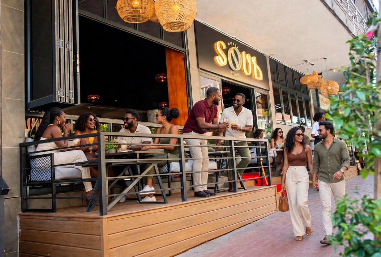 Guests seated on the outdoor deck at Soul Music Food, beneath the glowing SOUL MUSIC FOOD sign
